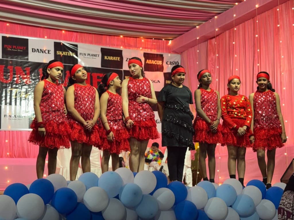 Western dance group in red costumes lined up on stage at Funplanet